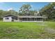 Rear exterior view of a home with a screened porch and lush green yard at 5525 Tillman Rd, Lakeland, FL 33810
