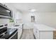 Modern kitchen with white cabinets, stainless steel appliances, island, and natural light, perfect for cooking at 5525 Tillman Rd, Lakeland, FL 33810