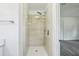 Modern shower with frameless glass door, rainfall shower head, and white honeycomb tile flooring at 5525 Tillman Rd, Lakeland, FL 33810