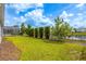 Backyard features a lush lawn, privacy hedges, and serene waterfront view at 8875 Backspin Ln, Champions Gate, FL 33896