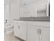 Bathroom with a large mirror, single sink vanity, toilet and a tub with a shower at 8875 Backspin Ln, Champions Gate, FL 33896