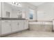Bright bathroom featuring dual vanities and a soaking tub at 8875 Backspin Ln, Champions Gate, FL 33896