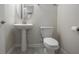 Bathroom featuring white toilet, pedestal sink, round mirror, and neutral paint at 8875 Backspin Ln, Champions Gate, FL 33896