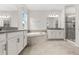 Bright bathroom featuring dual vanities, a tiled tub, and a glass-enclosed shower at 8875 Backspin Ln, Champions Gate, FL 33896