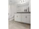Bathroom with a large mirror, single sink vanity, toilet and a tub with a shower at 8875 Backspin Ln, Champions Gate, FL 33896
