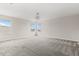 Spacious bonus room with neutral carpet, natural light, and a decorative chandelier at 8875 Backspin Ln, Champions Gate, FL 33896