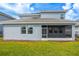 Back of the home features a large covered patio, windows, and well-maintained lawn at 8875 Backspin Ln, Champions Gate, FL 33896