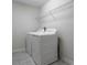 Bright laundry room with modern white washer and dryer, and overhead shelving at 8875 Backspin Ln, Champions Gate, FL 33896