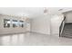 An empty living room with stairs and tile flooring is illuminated by modern lighting fixtures at 8875 Backspin Ln, Champions Gate, FL 33896