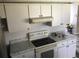 The kitchen features white cabinets, range, oven, and stone-look countertops at 1257 Dal Maso Dr, Daytona Beach, FL 32117