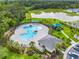 Aerial view of the community pool, playground, and nearby pond surrounded by lush landscaping and trees at 1335 Berry Ln, Davenport, FL 33837