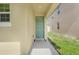A welcoming front door with a cute doormat is framed by a light green exterior at 1335 Berry Ln, Davenport, FL 33837