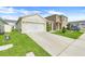 This single-Gathering home features a two-car garage and well-maintained lawn, adding to its curb appeal at 1335 Berry Ln, Davenport, FL 33837