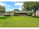 View of the home's back exterior with a screened patio and nice landscaping at 2825 Woodcrest Ln, Lakeland, FL 33805