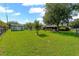 Spacious backyard with green grass, mature trees, shed, and partial view of the home's exterior at 2825 Woodcrest Ln, Lakeland, FL 33805
