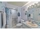 Blue-toned bathroom with patterned shower curtain, decorative mirror, and vanity sink at 2825 Woodcrest Ln, Lakeland, FL 33805