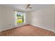 A cozy bedroom with a ceiling fan and a window view of the green lawn, offering a comfortable and relaxing atmosphere at 2825 Woodcrest Ln, Lakeland, FL 33805