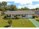 Charming single-story home with well-manicured lawn, flower beds, and blue sky at 2825 Woodcrest Ln, Lakeland, FL 33805