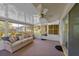Relaxing sunroom with comfortable seating, ceiling fan, and views of the private backyard, perfect for leisure at 2825 Woodcrest Ln, Lakeland, FL 33805