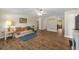 Open-concept living room with wood floors, ceiling fan, and bright, neutral walls at 2825 Woodcrest Ln, Lakeland, FL 33805