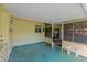 Covered patio area with painted floor, open windows with screens, and a comfortable place to sit and relax at 2825 Woodcrest Ln, Lakeland, FL 33805
