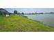 Lush green backyard sloping gently to a serene lake, offering peaceful views at 2528 Ladoga Dr, Lakeland, FL 33805