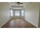 Bedroom featuring tray ceiling with fan, wood-look flooring, and bright natural light at 2528 Ladoga Dr, Lakeland, FL 33805