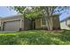Exterior view of the home showcasing the lawn, facade, and landscaping at 2528 Ladoga Dr, Lakeland, FL 33805