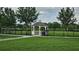 Community gazebo with seating overlooks a grassy lawn and is surrounded by mature trees and a black fence at 2528 Ladoga Dr, Lakeland, FL 33805