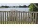 Picturesque lake view from the backyard with a charming fence and lush vegetation at 2528 Ladoga Dr, Lakeland, FL 33805