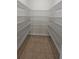 Walk-in pantry featuring tile flooring, base molding and floor-to-ceiling metal shelving for ample storage at 2528 Ladoga Dr, Lakeland, FL 33805