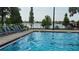 Community swimming pool provides a refreshing escape, with mature landscaping and lounge chairs around the deck at 2528 Ladoga Dr, Lakeland, FL 33805