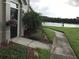 Charming home entrance with landscaped walkway, flowering plants and view of the water at 9053 Lee Vista Blvd # 1405, Orlando, FL 32829