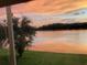 Sunset view of a peaceful lake from the home's window, offering a serene escape at 9053 Lee Vista Blvd # 1405, Orlando, FL 32829