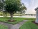Lakeside view with lush green grass, mature trees, and serene water creating a tranquil atmosphere at 9053 Lee Vista Blvd # 1405, Orlando, FL 32829