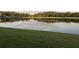 Scenic view of a serene pond reflecting the sky, surrounded by lush green grass and trees at 9053 Lee Vista Blvd # 1405, Orlando, FL 32829