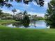 Beautiful waterfront view featuring lush green grass, palm trees, and scenic buildings creating a tropical paradise at 9053 Lee Vista Blvd # 1405, Orlando, FL 32829