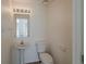Cozy half bathroom with a pedestal sink, modern toilet, and bright lighting at 4444 Withrowwood Ct, Orlando, FL 32837