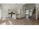 Open-concept living space with a modern kitchen, elegant staircase, and abundant natural light at 4444 Withrowwood Ct, Orlando, FL 32837