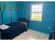 Quaint bedroom painted with blue walls, features an exterior window view, and a cozy bed at 3453 Duff Rd, Lakeland, FL 33810