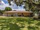 Expansive backyard with a well-maintained lawn, patio, and mature trees, perfect for outdoor activities at 6909 Farris Dr, Lakeland, FL 33811