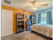 Bedroom featuring a bed, neutral carpet, ceiling fan, and built-in bookshelves at 6909 Farris Dr, Lakeland, FL 33811