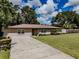 Charming single-story home showcasing a well-manicured lawn and a welcoming driveway at 6909 Farris Dr, Lakeland, FL 33811