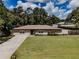 Charming single-story home featuring a lush green lawn and a lovely brown metal roof at 6909 Farris Dr, Lakeland, FL 33811