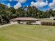View of single-story home with well maintained lawn, and a long driveway on a sunny day at 6909 Farris Dr, Lakeland, FL 33811