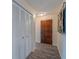 Hallway view featuring a wood door, vinyl floors and a closet with shutter doors at 6909 Farris Dr, Lakeland, FL 33811