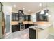 Modern kitchen with dark cabinetry, stainless steel appliances, and granite countertops at 9349 Mira Valle Ln, Winter Garden, FL 34787