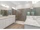 Spacious bathroom with dual sinks, granite countertops, and walk-in shower with tiled walls at 2132 Limestone Trl, Kissimmee, FL 34747