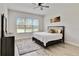 Bright bedroom features a large window with outdoor views, wood-look tile and art at 2132 Limestone Trl, Kissimmee, FL 34747