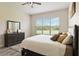 Cozy bedroom features a large window with outdoor views and dresser with mirror at 2132 Limestone Trl, Kissimmee, FL 34747